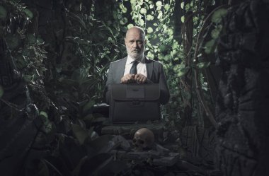 Ormanda kaybolmuş üzgün bir işadamı. Eski kalıntıların ve kafatasının yanında duruyor.