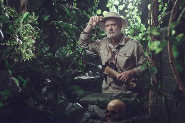 Cesur maceracı ormanı keşfediyor ve etrafına bakıyor, antik kalıntılar buluyor.