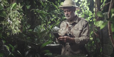 Tropikal ormanı keşfeden ve akıllı telefonuyla internete bağlanan maceraperest.