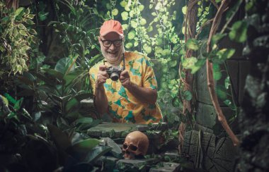 Ormanı keşfeden ve kamerasıyla fotoğraf çeken neşeli turist.