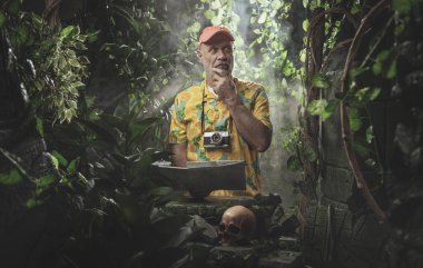 Korkak turist tropikal ormanda kayboldu, elinde bir harita var.