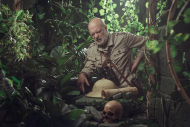 Ormanın kaşifi sırt ağrısı çekiyor, sırtına dokunuyor ve acı çekiyor.