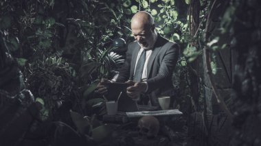 Ormanda dizüstü bilgisayarıyla bağlantı kuran kızgın bir işadamı. Şebeke çekmiyor ve çalışamıyor.