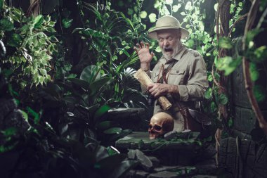 Kâşif ormanda yürürken bir insan kafatası buluyor. Korkuyor ve şok oluyor.