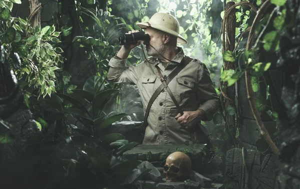勇敢的探险家在丛林中独行 他正透过双筒望远镜观察 — 图库照片