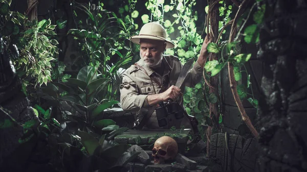 マチェーテとジャングルを歩く勇敢な探検家 彼は頭蓋骨と古代の遺跡を見つけます — ストック写真