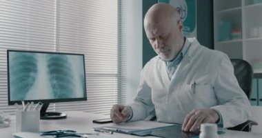 Profesyonel doktor ofisinde tıbbi kayıtları kontrol ediyor.