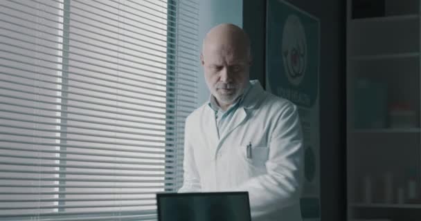 医者はオフィスの机に座って働いてる — ストック動画