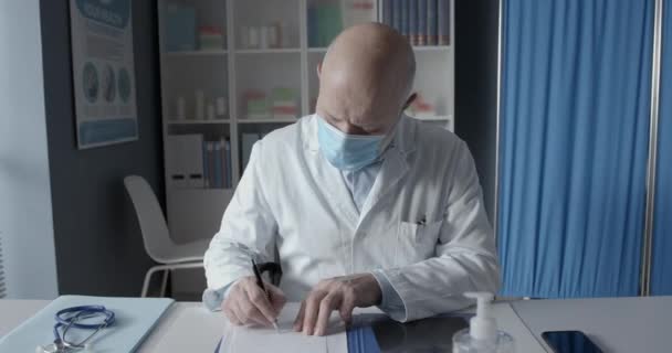 Doctor with surgical mask giving a prescription — Stock Video