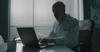 Dizüstü bilgisayarda yazan profesyonel bir doktor.