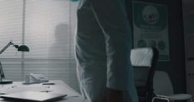 Yorgun doktor maskesini çıkarıyor.