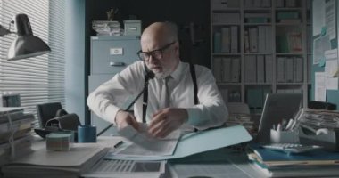 Ofis çalışanı telefonlara bakıyor.