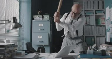 Kızgın işadamı bilgisayarını yok ediyor.