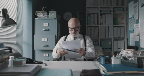 Наголошений бізнесмен відкидає документи і відчуває себе виснаженим — стокове відео