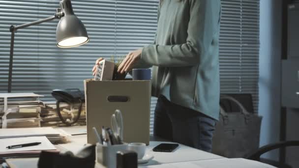 Vrouw inpakken van haar bezittingen na het verliezen van haar baan — Stockvideo