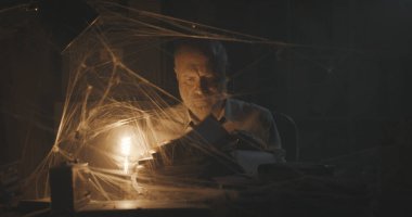 Terk edilmiş bir ofiste evrak arayan şirket işadamı: başarısızlık, mali kriz ve modası geçmiş iş konsepti