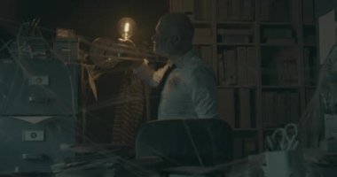 İşadamı, eski dosyalarını kaybolan ofisinde arıyor.