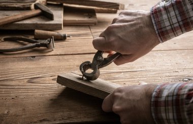 Marangoz eski ahşap çivileri sökmek için kıskaç, marangozluk konsepti kullanıyor.