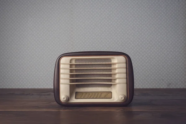 Vintage radio on the table and vintage wallpaper: music and entertainment concept, blank copy space