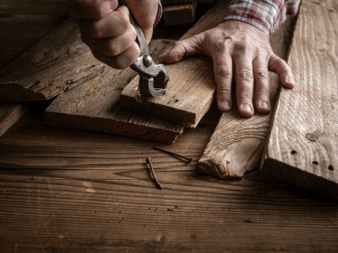 Marangoz eski ahşap çivileri sökmek için kıskaç, marangozluk konsepti kullanıyor.