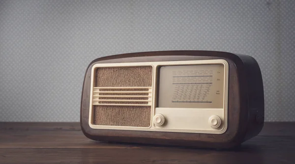 Vintage radio on the table and vintage wallpaper: music and entertainment concept, blank copy space