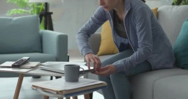 Evde çalışan ve evrakları kontrol eden bir kadın.