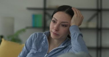 Üzgün kadın evde tek başına ağlıyor.