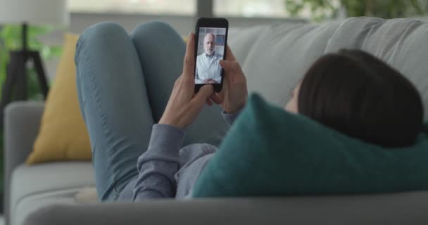 Mujer vídeo llamando a su médico con su teléfono inteligente — Vídeos de Stock