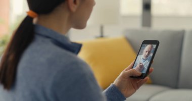 Kadının doktoruyla görüntülü konuşma yapması, teletıp konsepti.