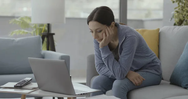Evdeki Kanepede Oturan Dizüstü Bilgisayarında Video Izleyen Genç Bir Kadın — Stok fotoğraf