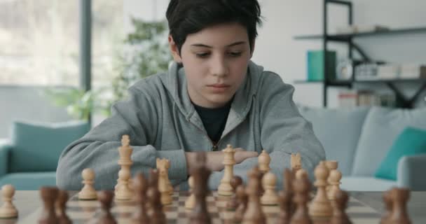 Intelligent pojke spelar schack hemma — Stockvideo