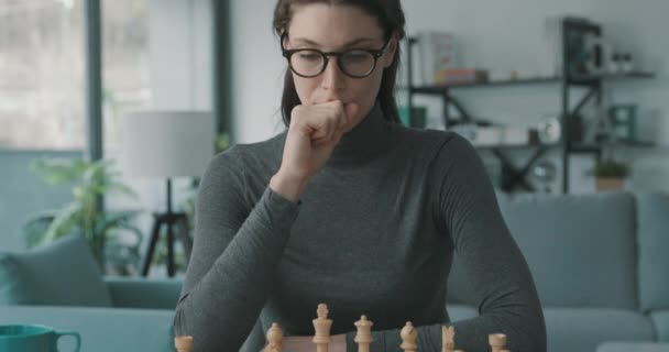 Vrouw beweegt een stuk op het schaakbord — Stockvideo