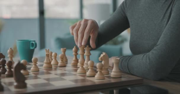 Vrouw die de koning op het schaakbord zet — Stockvideo