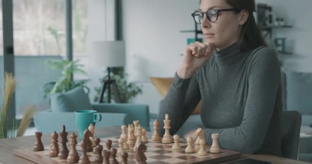 Slimme vrouw die thuis schaak speelt — Stockvideo