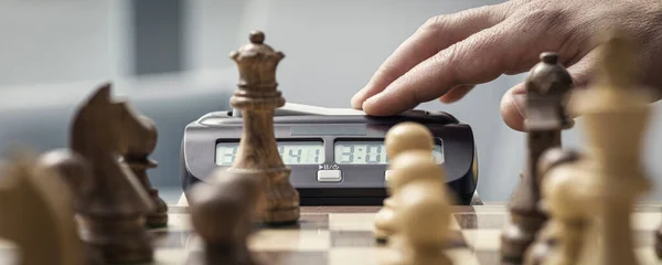 Chess player hitting the chess clock: chess tournament and competition concept