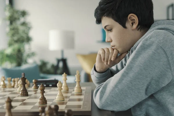 Jogo de sucesso da competição homem concentrado desenvolvendo estratégia de xadrez  jogando jogo de tabuleiro com amigo movendo peça durante torneio de xadrez  movendo peças no tabuleiro de xadrez homem segura peça