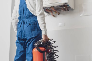 Tesisatçı profesyonel araçlar kullanarak kazanı kontrol ediyor, kazan hizmeti kavramı