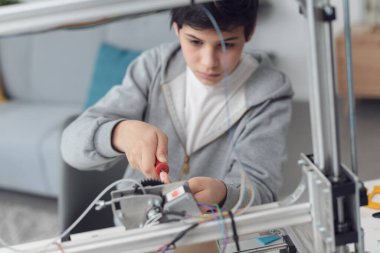 Akıllı çocuk evde 3D yazıcı, bilim ve teknoloji konseptini kullanmayı öğreniyor.