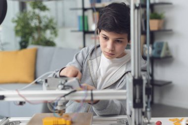Akıllı çocuk evde 3D yazıcı, bilim ve teknoloji konseptini kullanmayı öğreniyor.