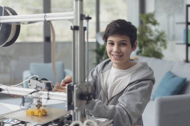 Akıllı çocuk evde 3D yazıcı, bilim ve teknoloji konseptini kullanmayı öğreniyor.