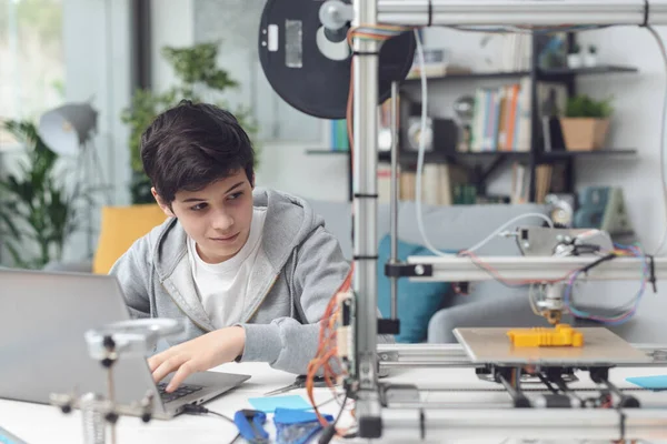 Akıllı öğrenci evde 3D baskı öğreniyor, bir dizüstü bilgisayar kullanıyor ve bir prototip basıyor