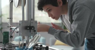 Laboratuvarda 3D yazıcı kullanan zeki bir öğrenci.