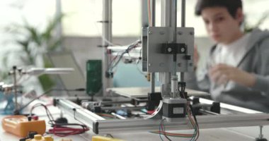 Laboratuvarda 3D yazıcı kullanan zeki bir öğrenci.