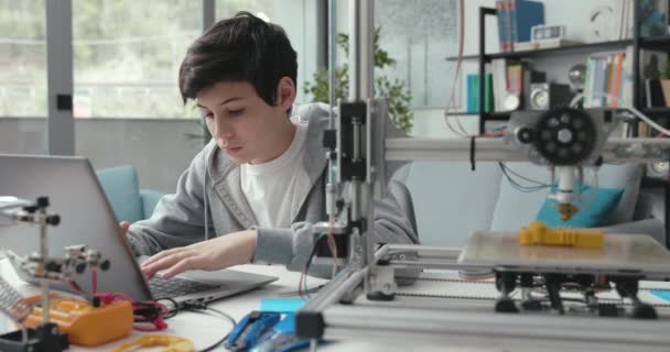 Студент с помощью 3D-принтера дома — стоковое видео