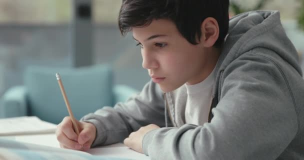 Chytrý student sedící za stolem a studující — Stock video