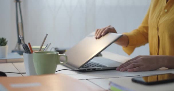 Mujer sentada en el escritorio y conectándose con su leptop — Vídeo de stock