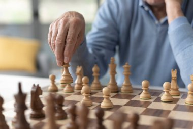 Son sınıf öğrencisi satranç oynuyor ve satranç tahtasına taş koyuyor.