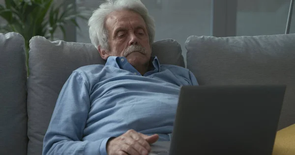 Uomo Anziano Seduto Sul Divano Casa Collegato Con Computer Portatile — Foto Stock