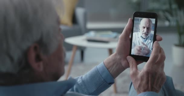 Hombre mayor de vídeo llamando a su médico — Vídeos de Stock