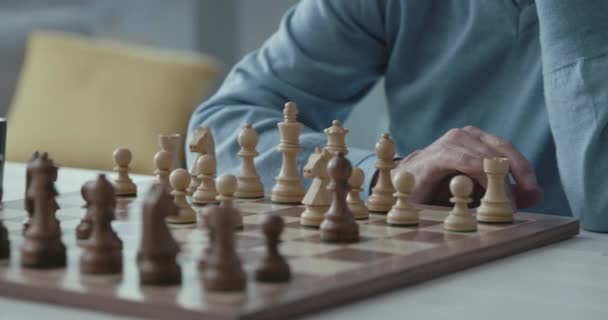 Senior man spelar schack hemma — Stockvideo